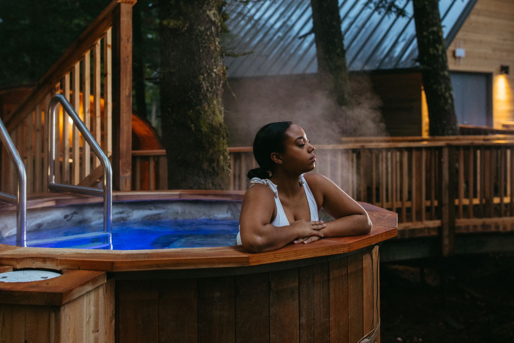 A woman relaxes in an outdoor hot tub at Alyeska Nordic Spa in Girdwood