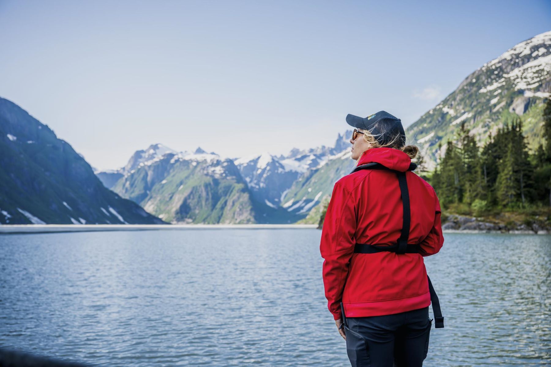 Woman looking out at river and mountains in Alaska