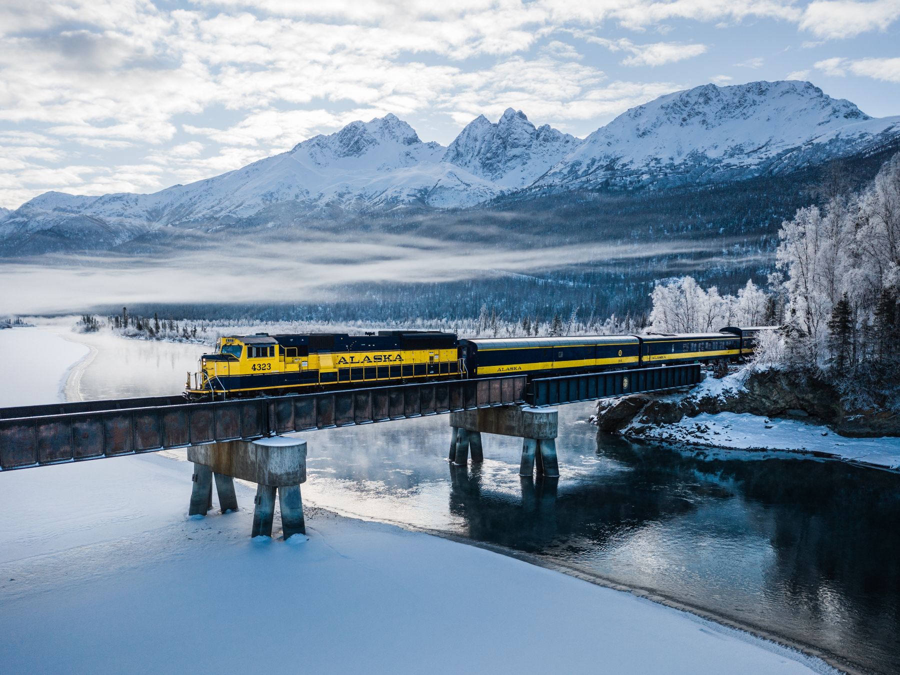 Aurora Winter Train traveling over a bridge in winter