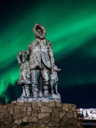 Northern lights behind a statue in downtown Fairbanks