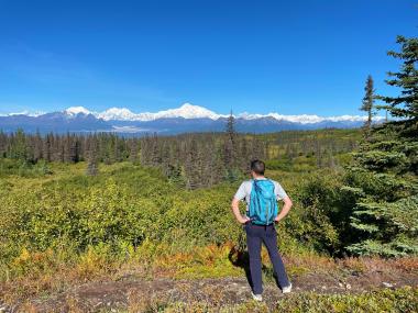 Hiker looks out at Denali in Denali State Park Alaska