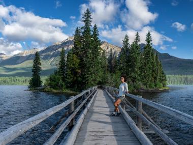A woman enjoys the scenery on a bridge in Canada's Alberta