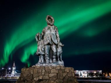Northern lights behind a statue in downtown Fairbanks