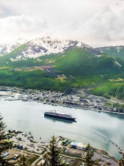 A cruise ship sails by the town of Juneau, Alaska