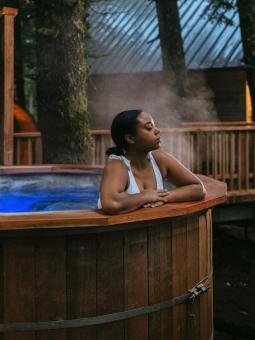 A woman relaxes in an outdoor hot tub at Alyeska Nordic Spa in Girdwood