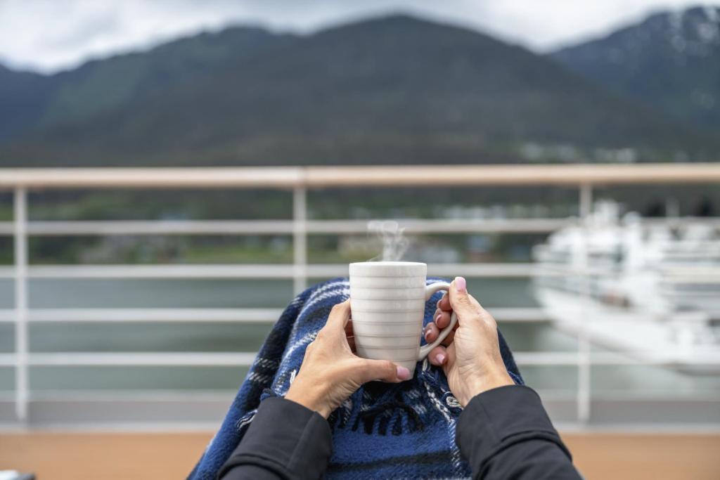 Passenger enjoying a hot beverage on a cruise ship in Juneau