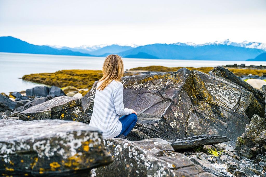 Woman sitting on rocks on Petroglyph Beach