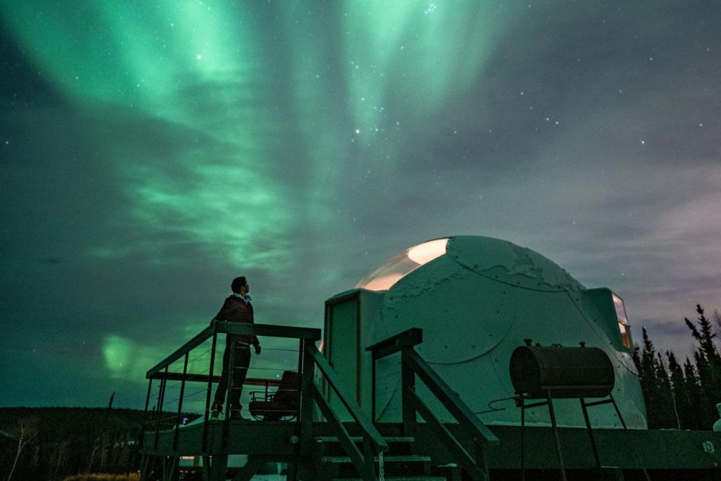 A person views the northern lights from Borealis Basecamp in Fairbanks