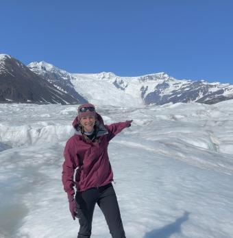 A hiker points across the Root Glacier toward the Stairway Icefall  Photo